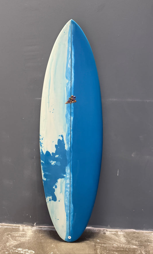 Blue and white surfboard on a gray surface